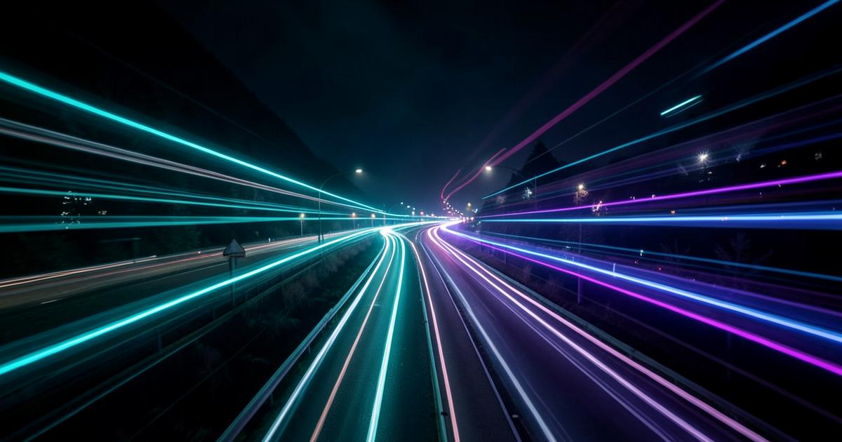 Teal and purple light trails on a night highway